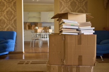 A man organizes his book collection in a new home, creating a comfortable, minimalist setup