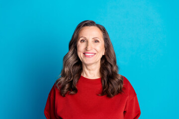 Obraz premium Photo of pretty aged lady beaming smile empty space wear red pullover isolated on blue color background