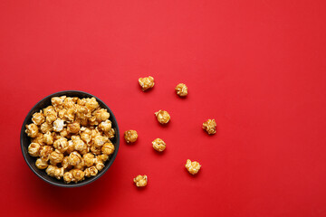 Bowl with tasty popcorn on red background