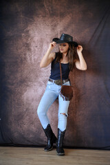 Beldade mulher vaqueira com chapéu country moda rural calça jeans e cinta 