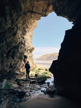 Person stood in the entrance of a sea cave