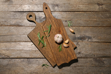 New cutting boards with garlic and rosemary on wooden background