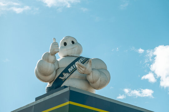 Madrid, Spain - February 16, 2024:  Michelin Man the official mascot of French tire manufacturer against a blue sky with white clouds