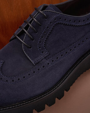 Blue Suede Brogue Shoe on Wood Background