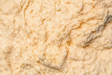 Texture of rolled dough. Background of the dough for baking. Fresh raw dough for pizza or bread baking. Close-up fermented doughs, homemade