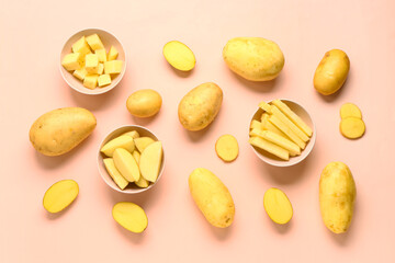 Bowls with cut and whole potatoes on pink background