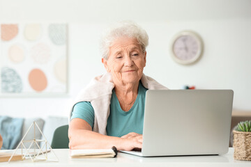 Senior woman using laptop at home