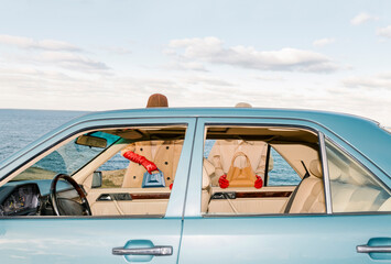 Elegant Woman with Bag in Vintage Car by the Sea