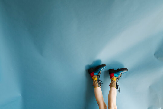 Colorful Boots and Legs Against Light Blue Background