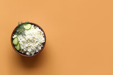 Bowl of tasty cottage cheese on orange background