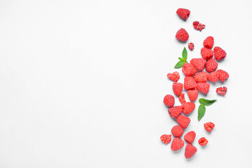 Many fresh raspberries and mint on blue background