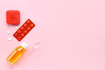 Bottle with medicine and pills on pink background