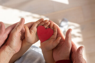 multi generation family concept, love and care, hands holding heart