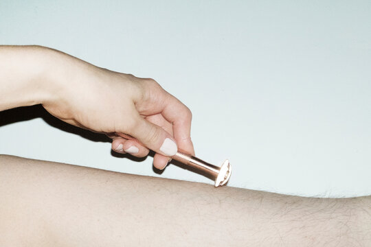 Realistic photo of shaving body hair with shaver/razor with flashlight