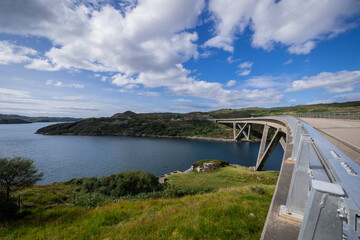 The image is of the Kylesku Bridge in Scotland, which spans Loch a' Chàirn Bhàin in Sutherland. It is a concrete bridge. 