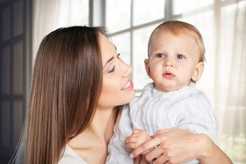 a mother with cute newborn baby hugs and kisses