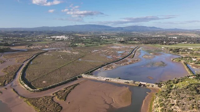 Aerial view on the typical Algarvian countryside in Portugal. The estuarine system of Alvor river, agricultural fields and the old damb