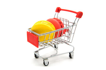 Shopping supermarket cart with colorful varied assortment macarons cookies isolated on a white...