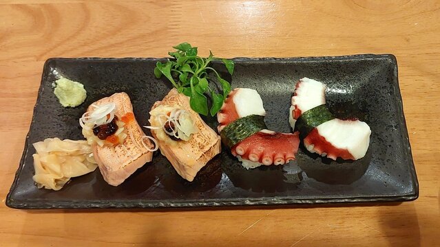 sushi salmon aburi nikiri and tako nikiri on a plate