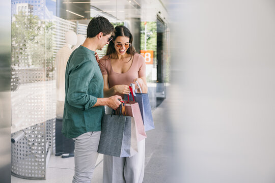 Happy couple with shopping bags in Azca, Madrid on a sunny day