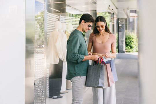 Couple Shopping in Azca, Madrid with Bags Outside Store