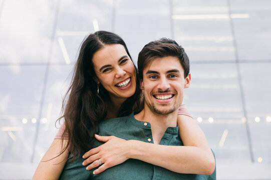 Happy couple smiling and embracing outside modern building in Azca