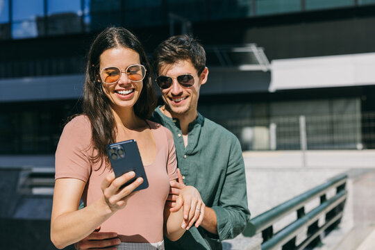 Couple enjoying a moment looking at a smartphone in Azca, Madrid