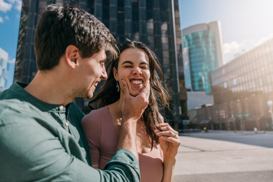 Young couple making funny faces in Azca, Madrid, on a sunny day