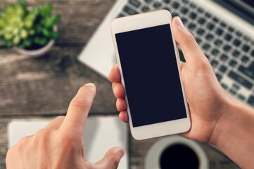 Hand typing on smartphone with blank screen