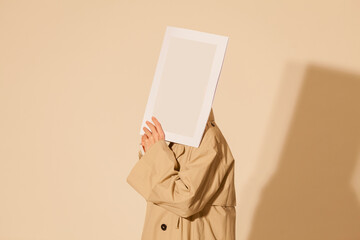 Anonymous Person Holding Blank Frame Against Beige Background