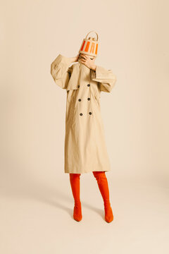 Fashionable Person Wearing Beige Trench Coat and Orange Accessor