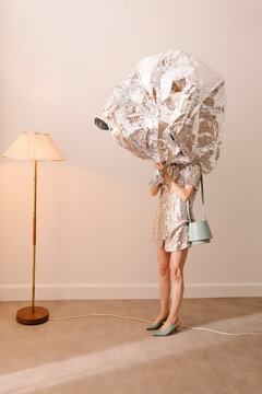 Person Wearing Metallic Foil Headpiece in Quirky Art Setup