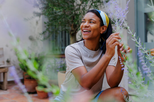 Woman gardening and enjoying lavender scent in a sunny garden