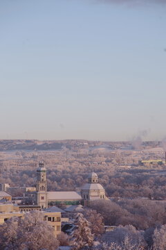 A snowy cityscape with a church and a tower in the background