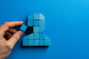 A hand building a person from wooden blocks. Career development and hiring recruitment concept