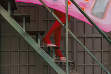 Woman Walking Up Stairs With swimming mattress