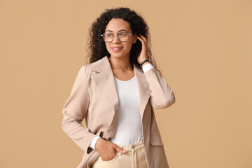 Young African-American businesswoman on brown background