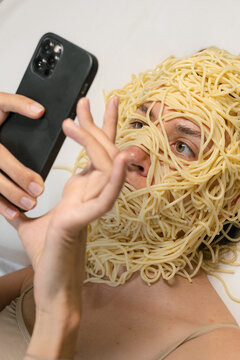Woman Covered In Spaghetti Uses Phone