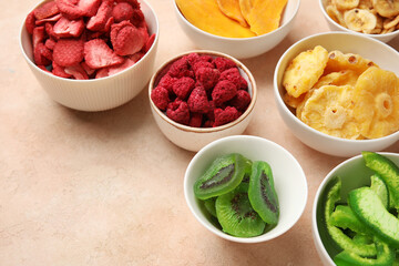 Bowls of different dehydrated fruits and berries on beige background