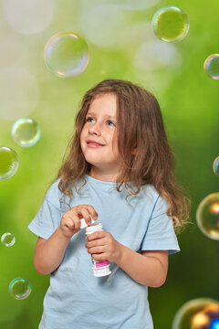 Lovely child admiring and looking at clear air bubbles