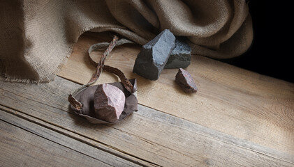 An antique leather sling lies on wooden desk