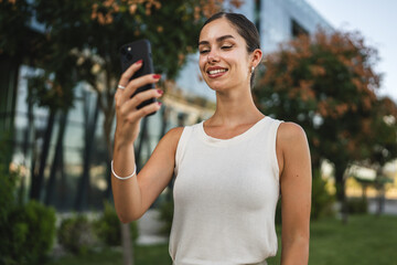 Young woman stand in front company have video call on mobile phone