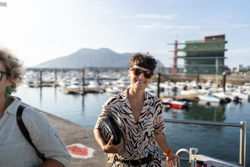 Stylish woman smiling while walking in a marina