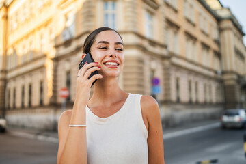Portrait of young beautiful woman talk on mobile phone on the street