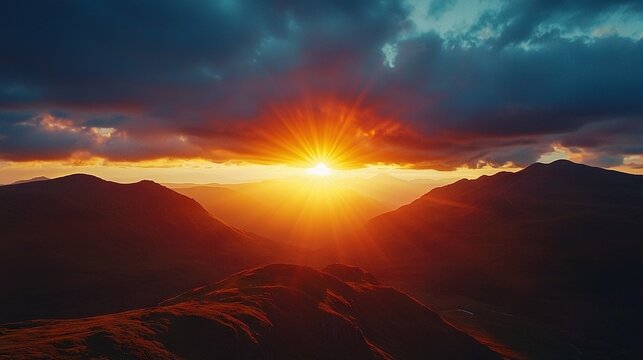   The sun sets over distant mountains, casting dark clouds above