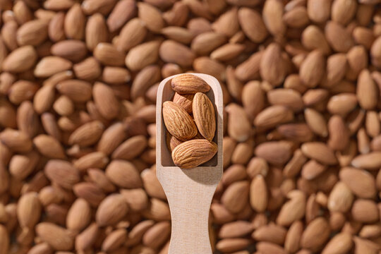 Pile of Raw Almonds with Scoop on Almond Background
