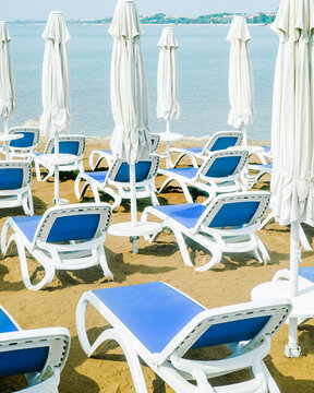 Empty sunbeds and closed sun umbrellas to the beach