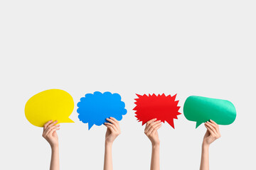Female hands with colorful speech bubbles on white background