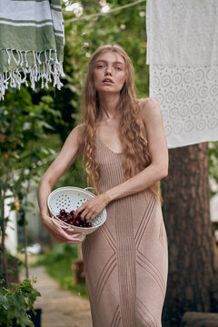 Woman Holding Cherries in a Colander