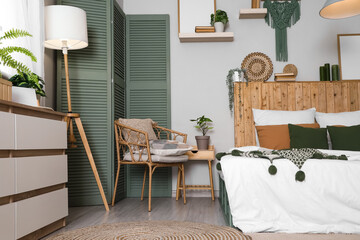 Interior of stylish bedroom with cozy bed, standard lamp and houseplants